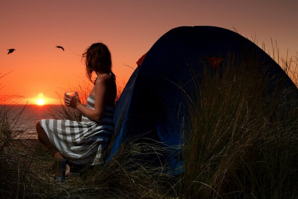 Pôr do sol brilhante e menina na tenda