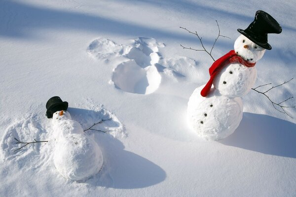 Dois bonecos de neve com chapéus pretos