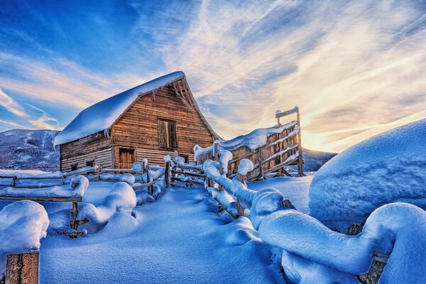 Paisaje de invierno. Casa de madera con valla