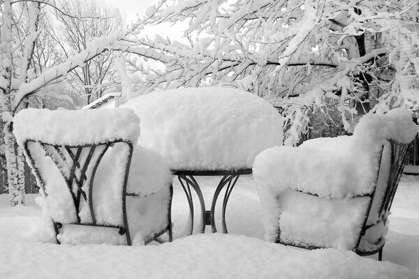 Schneebedeckter Tisch und Stühle