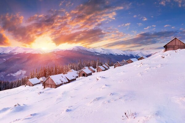 Case di neve sul pendio al tramonto