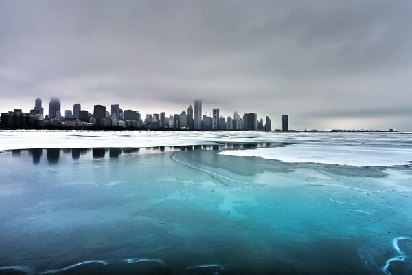 Im Winter gefrorenes Wasser vor dem Hintergrund der Stadt