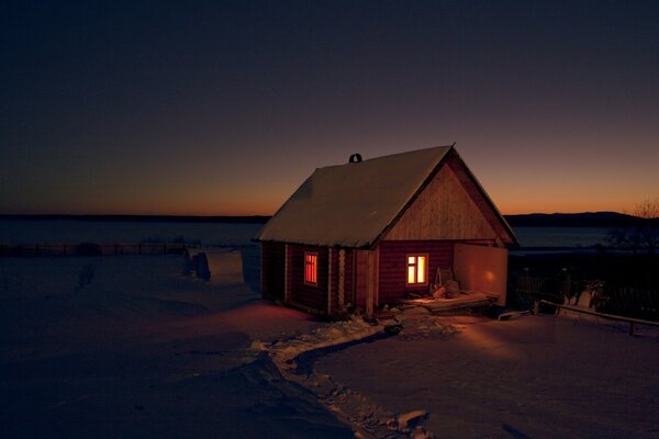 A house in a winter field at night