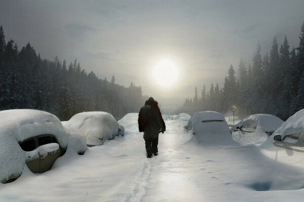 A man on a winter road towards the sun