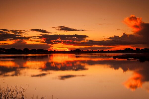 Schöner Blick auf den Sonnenuntergang am See in orangefarbenen Farben