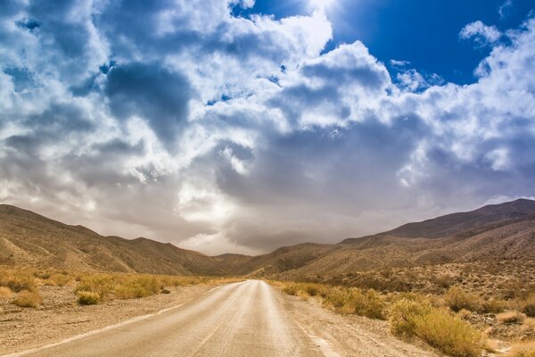 Camino en el desierto entre las colinas calvas