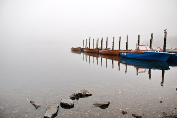 Barcos en el muelle en la niebla