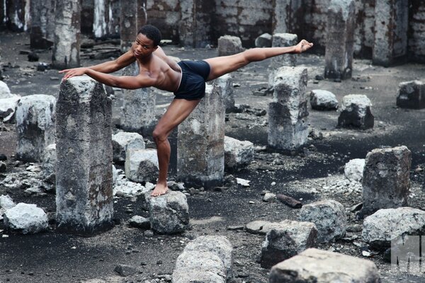 A man does yoga in the fresh air among the stones