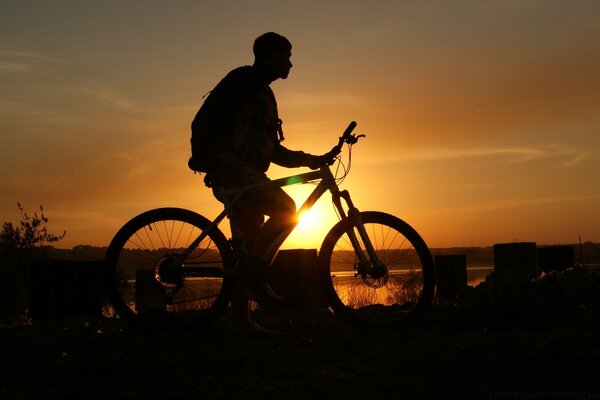 Cycliste promenades dans la soirée au coucher du soleil