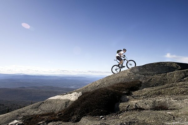 Un ciclista sube a la cima de una montaña