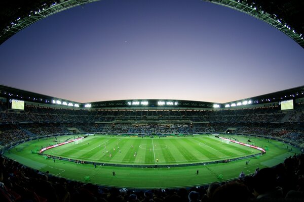 Noche. Estadio de fútbol con aficionados