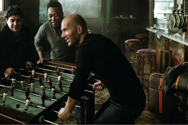 Hombres en un pub jugando futbolín