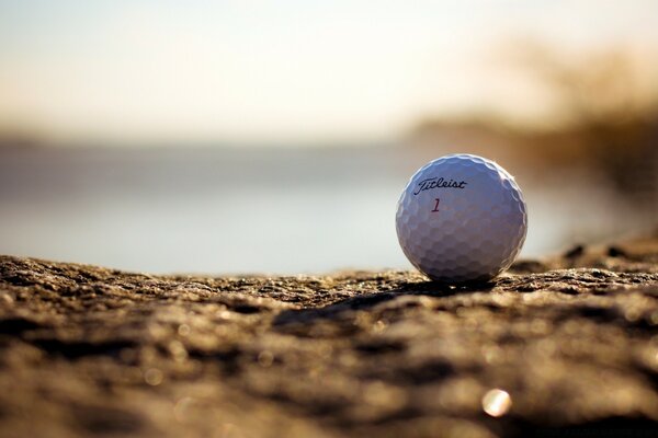 Macro golf ball on the sand