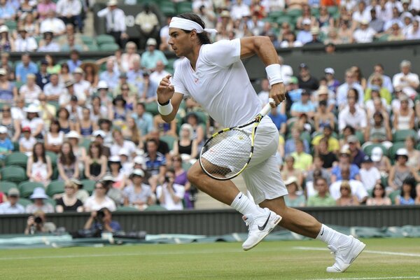 Tennisspiel. Aufgepumpter Tennisspieler läuft über das Feld