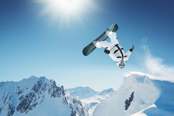 Stunt snowboarder dans les montagnes