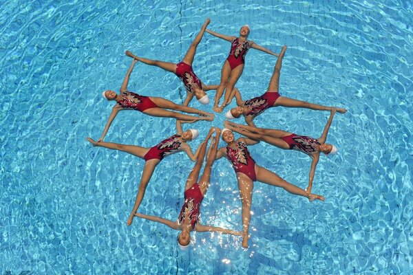 Mädchen vom Synchronschwimmen zeigten ein Muster