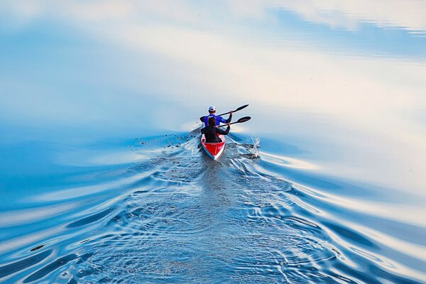 Uomo in canoa a vela dalla macchina fotografica