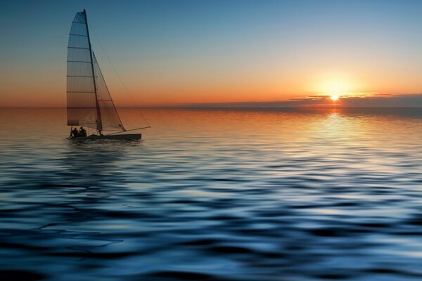 Sailboat on the surface of the sea at sunset