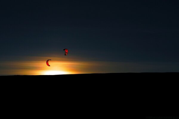 Gleitschirmflieger hoch am Himmel bei Sonnenuntergang