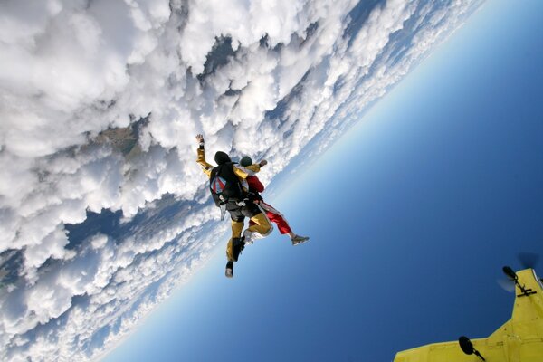 Parachutists soar in the air above the clouds