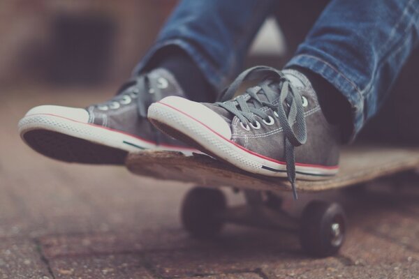 Pieds dans des chaussures sur une planche à roulettes