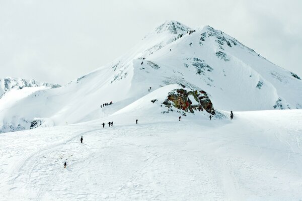 Esquiadores descem do topo da neve