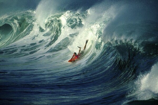 A surfer is lying on a board in the sea