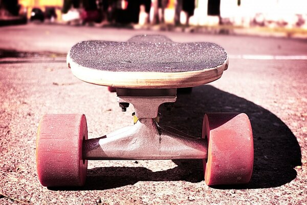 An old skate stands on the road in front of a crowd