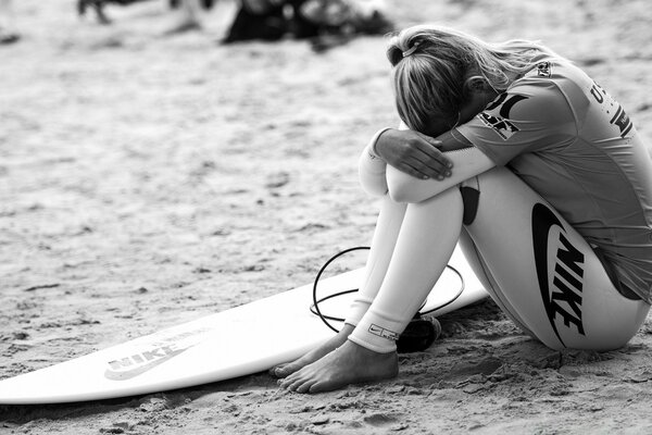 Ein Mädchen mit einem Surfbrett in Schwarz-Weiß-Tönen