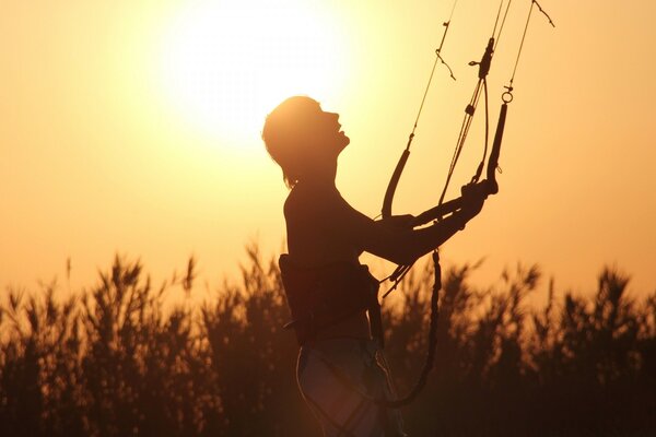 Silhouette eines Fallschirmspringers mit Schlingen im Gras