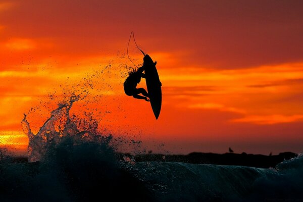 Silhouette of a surfer in the evening sunset