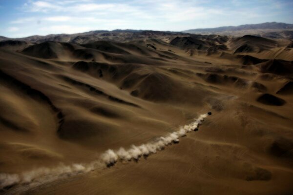 En el desierto conduce un coche de lejos de la arena no hay nada aquí