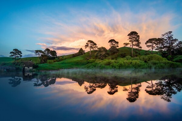 The sun rises against the background of green nature and water