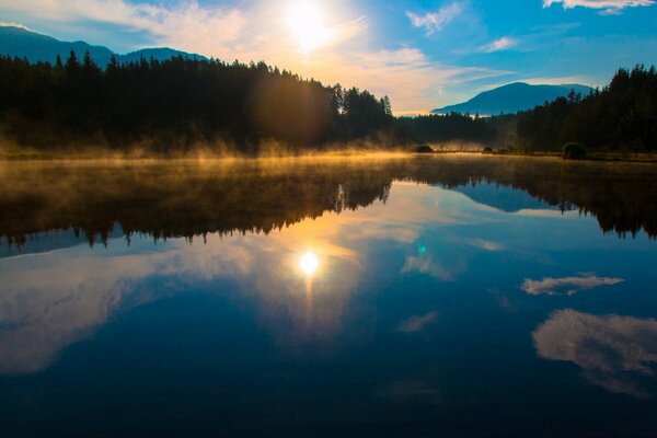 Amanecer en un lago helado en medio del bosque