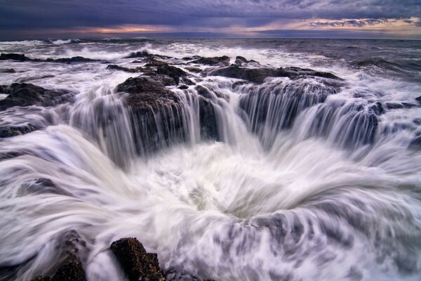 Ein Wasserfall, der mit einem Trichter im Ozean bedeckt ist