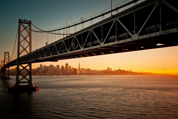 A bridge in America, cutting through the waters against the background of sunset