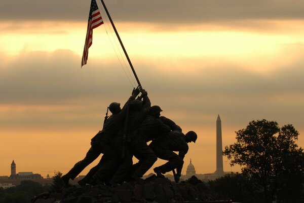 Silhouette of people with an American flag at sunset