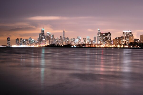 Cidade grande perto do oceano em luzes