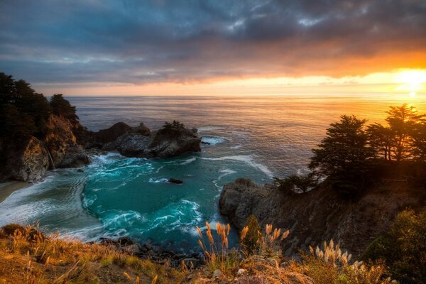 Beau coucher de soleil sur la plage rocheuse