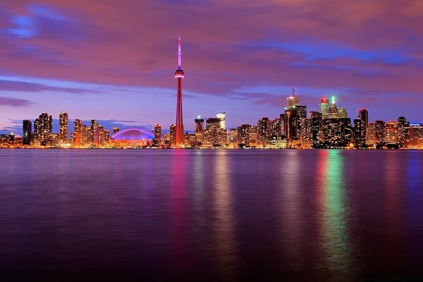 أضواء متعددة الألوان من المدينة تنعكس في الماء