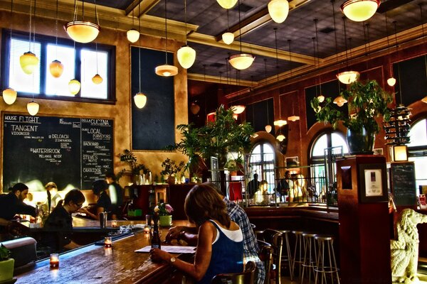 A girl and a guy are sitting in a bar, they are looking at the menu