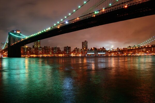 Brooklyn Bridge at Night in New York over the East River Strait