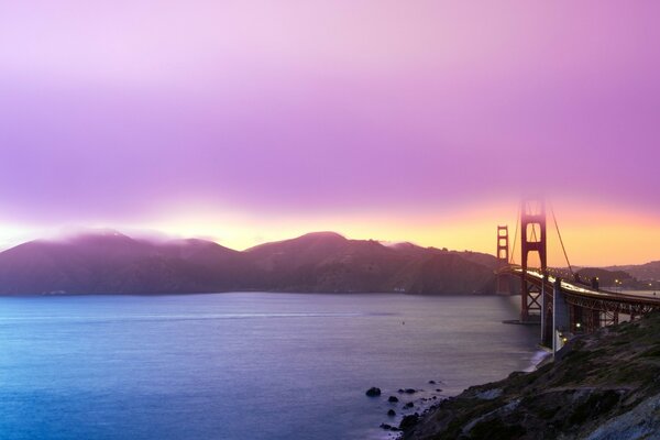 Красивый закат с видом на воду и мост