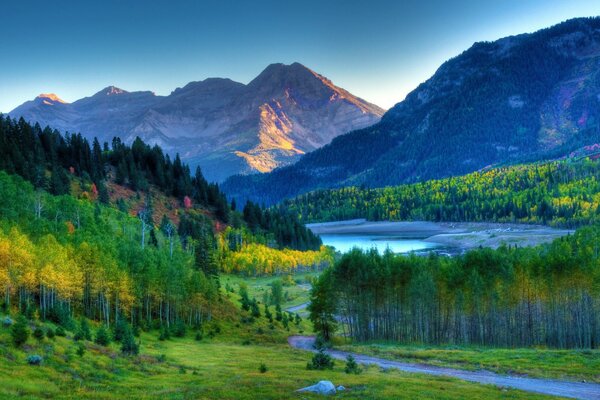 Amanecer sobre un río que fluye en un valle de montaña