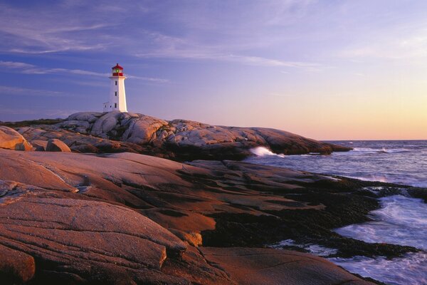 Faro al atardecer bajo el ruido de las olas