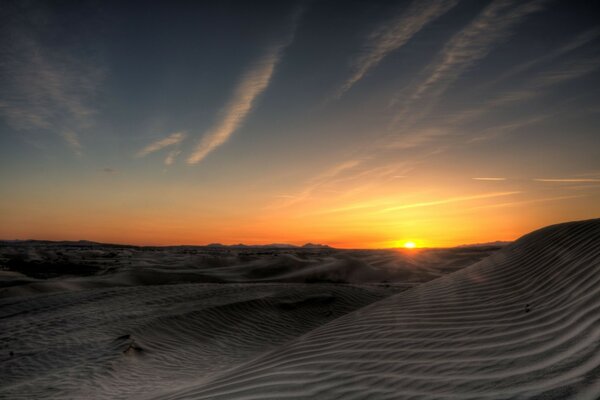 Coucher de soleil au milieu du désert et des dunes