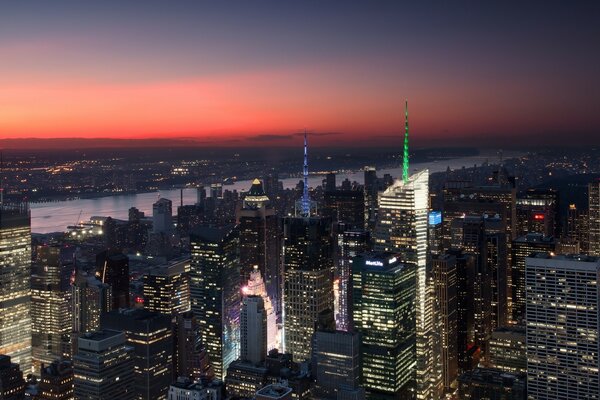 Cidade noturna e rio ao pôr do sol