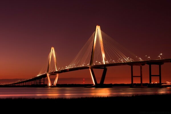 Ночной мост над водой освещаемый огнями