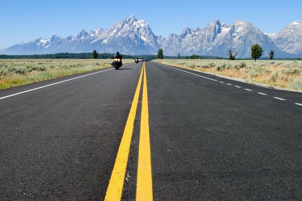 El camino que va a la distancia a las cimas de las montañas