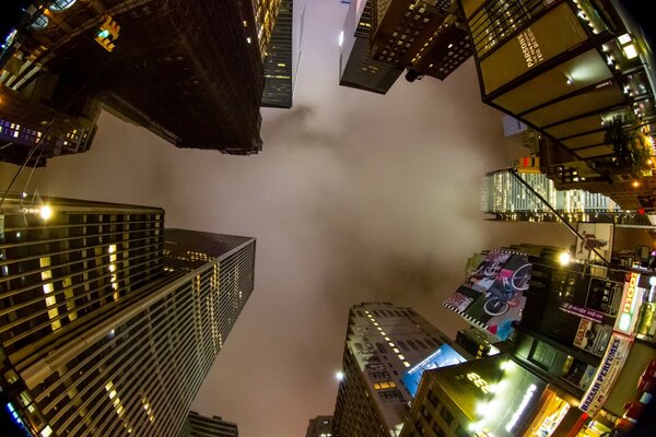 中心是雾中的夜空，周围是灯光中的摩天大楼